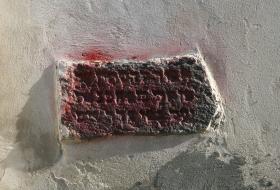 Napis na kamieniu obok synagogi „Zabrania się oddawania moczu na mury Bożnicy”.