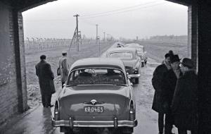 Eskortowani przez Milicję Obywatelską prawnicy sądu we Frankfurcie nad Menem wjeżdżają na teren obozu Auschwitz-Birkenau, grudzień 1964 r.