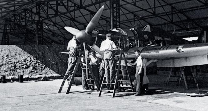 Mechanicy 303. dywizjonu podczas pracy w hangarze przy jednym z hurricane’ów, 1940 r.