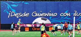 Mistrzowie świata i Europy na stadionie w Gniewinie, w tle fragment hasła, które można przetłumaczyć: Z Gniewina, niesiona marzeniami, naprzód Hiszpanio!