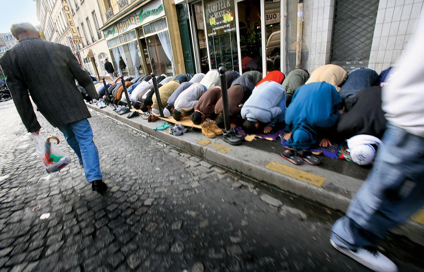 Paryż. Muzułmanscy imigranci modlą się na chodniku przed meczetem.