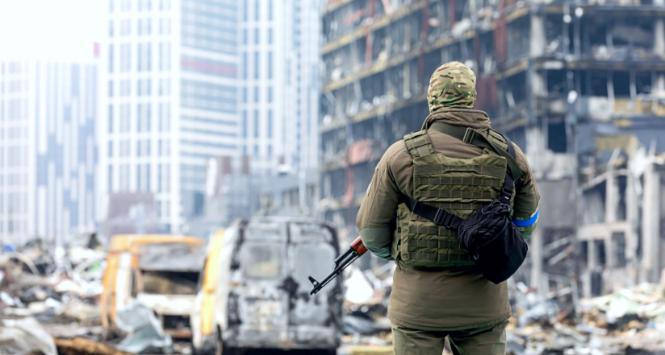 Ukraiński żołnierz na tle zrujnowanego centrum handlowego w Kijowie