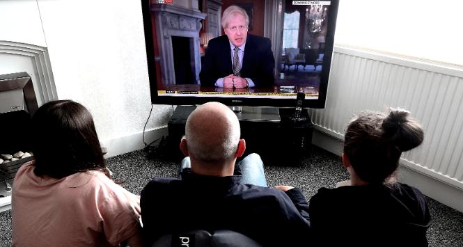 Rodzina w Liverpoolu ogląda wystąpienie premiera Borisa Johnsona.