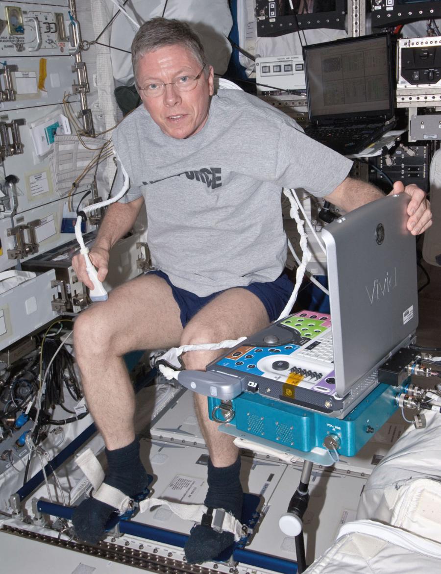 Astronauta Michael Fossum badający stan swoich mięśni nóg za pomocą ultrasonografu.
