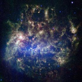 Wielki Obłok Magellana. Zdjęcie składa się z obrazu w podczerwieni i ujęcia optycznego. Pozchodzi z teleskopu kosmicznego Spitzer. Niebieskie obszary to formacje starszych gwiazd. Czerwone i brązowe to mgławice oświetlone promieniowaniem gwiezdnym.