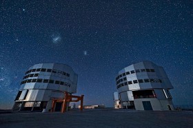 Very Large Telescope. Największy teleskop świata na wzgórzu Cerro Paranal w Chile. Składa się z czterech osmiometrowych zwierciadeł głównych i czterech prawie dwumetrowych pomocniczych. Na niebie - Wielki i Mały Obłok Magellana, a z lewej gwiazda Kanopus.