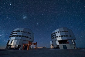 Very Large Telescope. Największy teleskop świata na wzgórzu Cerro Paranal w Chile. Składa się z czterech osmiometrowych zwierciadeł głównych i czterech prawie dwumetrowych pomocniczych. Na niebie - Wielki i Mały Obłok Magellana, a z lewej gwiazda Kanopus.