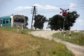 Tory niknące za zakrętem, wysoki nasyp, droga ukośnie dochodząca do przejazdu. W chwili wypadku nasyp był zarośnięty wysoką trawą, dodatkowo ograniczającą widoczność.