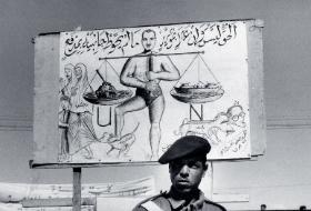 Egipski żołnierz przed plakatem poświęconym płk. Gamalowi Abdulowi Nasserowi.