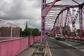 Głogów, pomalowany na różowo Most Tolerancji, w dole Odra, w tle gotycka kolegiata, początek Dolnośląskiej Drogi św. Jakuba
