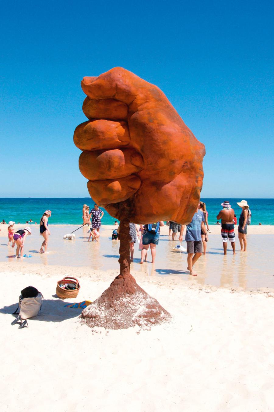 Rzeźba dłoni przesypującej piasek na australijskiej plaży w Cottesloe.