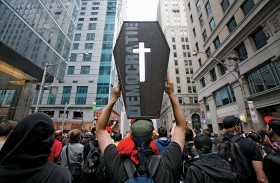 Jeden z demonstrantów protestu przeciw obradom grupy G20 w Toronto niesie imitację trumny z napisem „Demokracja”.