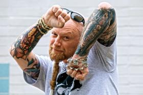 Blitz-Old Dziad, fotograf i lider punkowego zespołu Łeb Prosiaka, prezentuje przedramię z motywami warszawskimi jako kadrami filmowej kliszy.