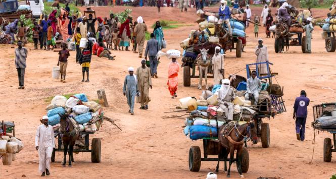 Ludzie uciekający przed przemocą w Darfurze Zachodnim przekraczają granicę z Adre w Czadzie, 4 sierpnia 2023 r.