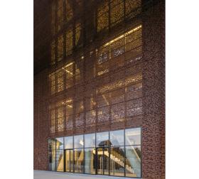 ... może dlatego, że jego ażurowa cortenowska elewacja z jednej strony nawiązuje do przemysłowego charakteru dzielnicy, z drugiej mimo potężnej skali ma w sobie pewną lekkość.