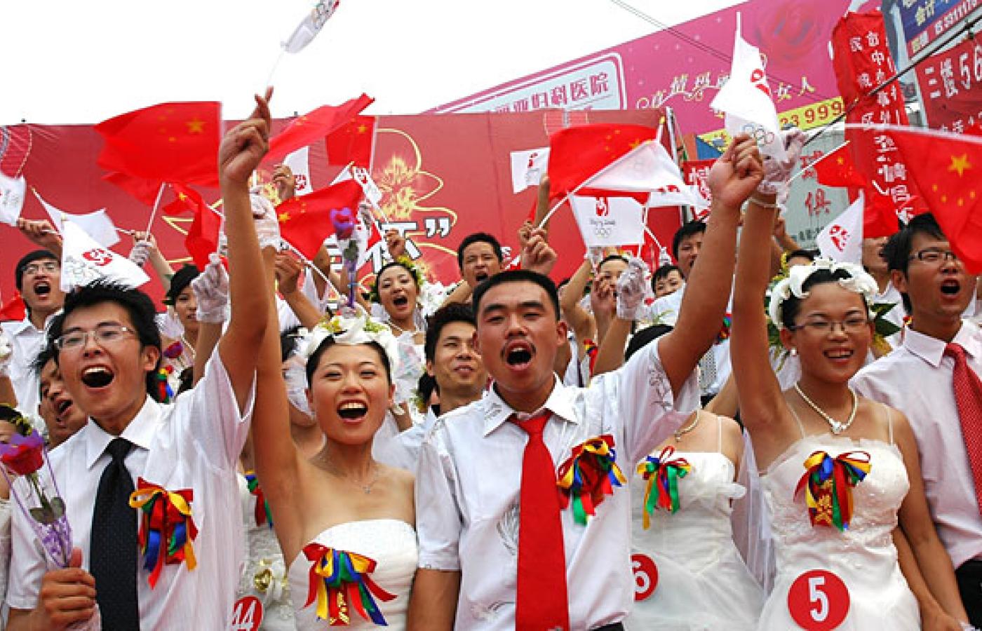 50 świeżo poślubionych par małżeńskich pozuje do fotografii na placu w mieście Binzhou 8 sierpnia 2008r. Cyfra 8 symbolizuje w Chinach pomyślność, a data zapisana numerycznie zawiera aż 3 ósemki (08.08.08) to szczęście potrójne. Fot. Reporter