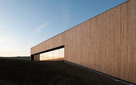 Lussy Sports Hall przy szkole Châtel-Saint-Denis niedaleko Lozanny. Dzieło studia Virdis Architecture. W konstrukcji wykorzystano pionowe listwy sosnowe, całość sprawia wrażenie, jakby nie wyszło się z lasu. To zwarta, monolityczna, zamknięta budowla ze skośnym dachem. Gmach efektownie odbija światło. Jest dwupoziomowy – na niższym poziomie znajdują się szatnie i hale sportowe. Na wyższym także znajdziemy hale, poza tym stołówkę. I, co ciekawe, otwarty korytarz, dzięki czemu widać, co się dzieje piętro niżej.