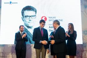 Laureat z dziedziny nauk społecznych, dr Adam Gendźwiłł, odbiera gratulacje od red. Jerzego Baczyńskiego.