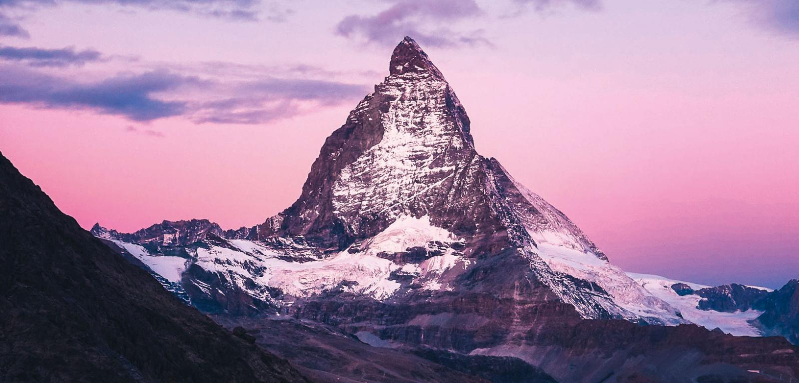 Wschodzące słońce oświetla wyniosłą piramidę Matterhornu, uważanego za najpiękniejszą górę Alp.