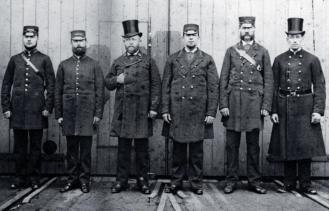 Pracownicy Brighton&South Coast Railway, od lewej: konduktor, inspektor biletowy (w Polsce rewident), zawiadowca stacji, dyżurny ruchu, strażnik i policjant; fotografia z 1881 r.