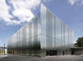 Datacube w Bazylei – ośrodek jednej z większych i najbardziej zaawansowanych w kraju bazy danych. Innowacyjny projekt przygotowało studio Ffbk Architects. W budowie wykorzystano efektowne, szare płyty stalowe, w których spektakularnie odbija się okolica (oraz niebo). Obiekt jest trzypiętrowy, sam magazyn ma 2,5 tys. m kw. Kto powiedział, że centrum bazy danych nie może się mieścić w budynku, który nadąża za trendami w architekturze?