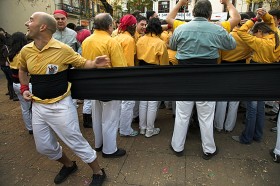 Członek Castellers de Badalona owija się faixa – tradycyjnym pasem długim nawet  na 8 metrów. Sant Andreu de Barcelona, 30.11.2008