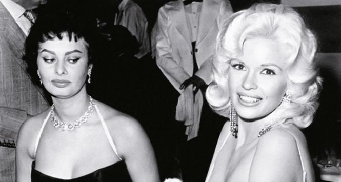 Sophia Loren zapatrzona w biust Jayne Mansfield na przyjęciu w restauracji Romanoff’s w Hollywood, 1957 r.