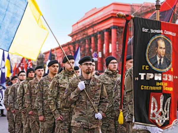 Kijów, marsz ku czci ukraińskich ochotników, żołnierze niosą portret Stepana Bandery.