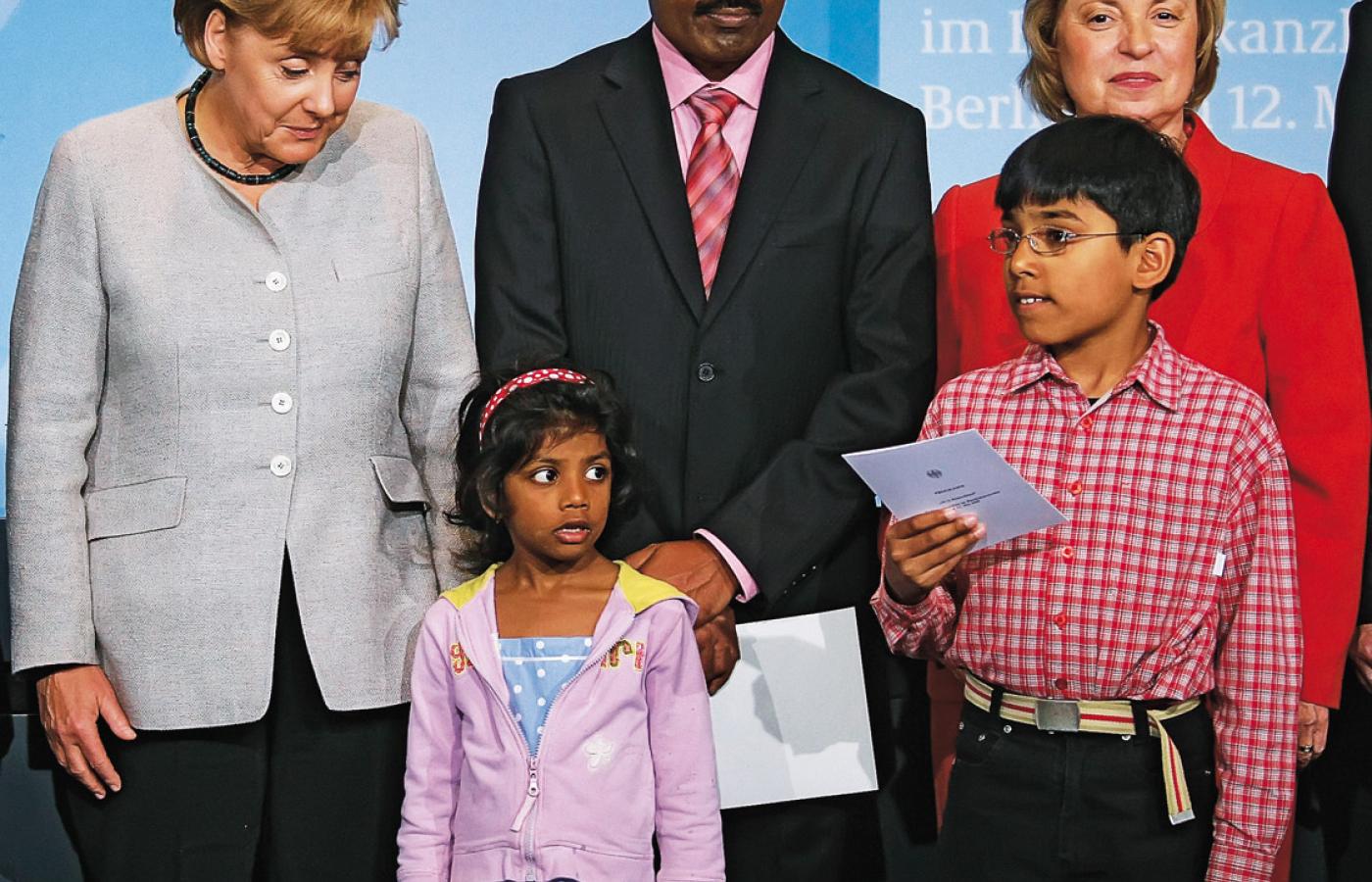 Kanclerz Angela Merkel z przybyłą z Indii rodziną, której przyznano obywatelstwo Niemiec.