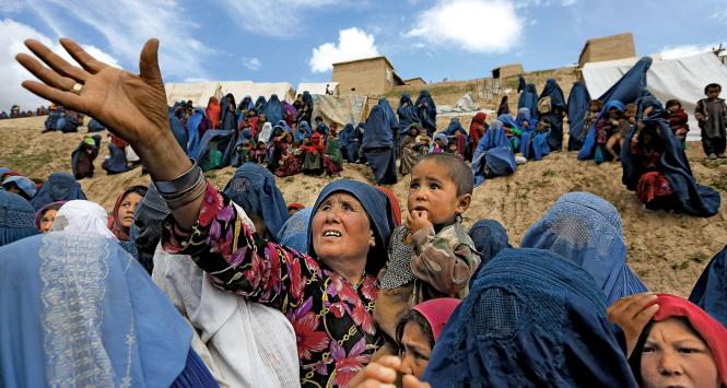 Afgańczycy ze zniszczonej przez osuwiska wioski czekają na transport z pomocą humanitarną.