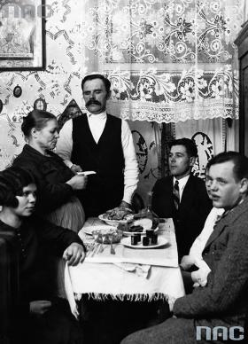 W innym domu, tego samego roku dużo skromniejsza wigilia. Łamanie się opłatkiem.