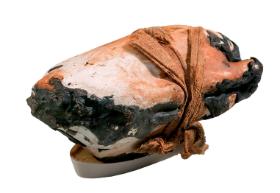 Drewniany pojemnik zawierający prawdopodobnie pieczonego gołębia.