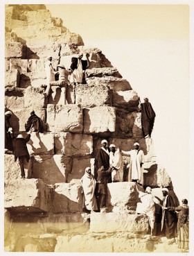 Grupa europejskich turystów wspina się na Wielką Piramidę, rok 1882, w prawym dolnym roku kobieta w stroju, w którym wspinać się nie da.