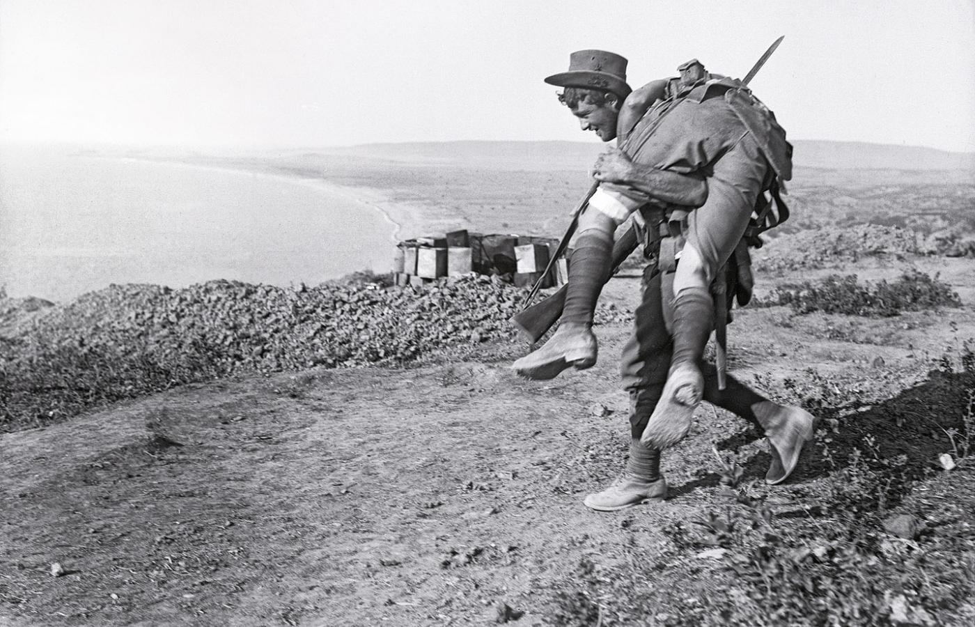Żołnierz sił ANZAC znosi rannego z pola walki, półwysep Gallipoli, 1915 r.