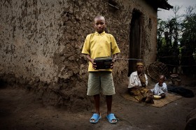 Jean Ngirinshuti, 14 lat. Ojciec jest w więzieniu, mieszka z siostrą i jej dzieckiem. Po szkole nosi wodę i pomaga siostrze w gotowaniu. Lubi swoje RADIO, może na nim słuchać wiadomości i muzyki. Będzie księdzem. Osada Pigmejów pod Ruhango, Rwanda
