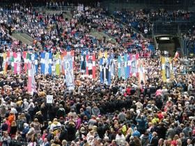 Procesja z wizerunkami polskich świętych podczas uroczystości na stadionie w Poznaniu.