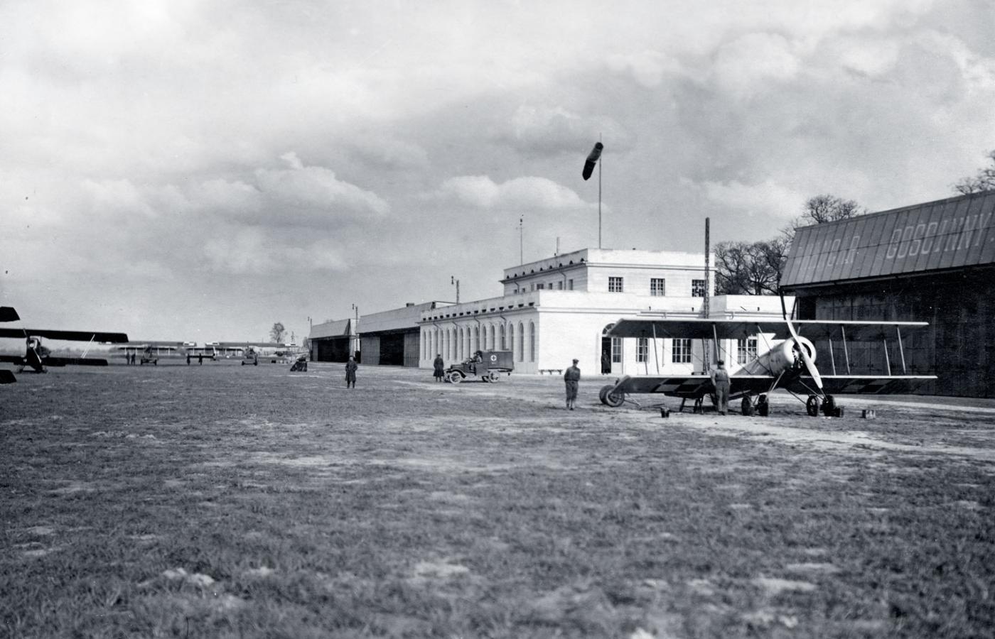Dębliński wojskowy port lotniczy i hangary szkoły. Na pierwszym planie szkolny dwupłatowiec hanriot.