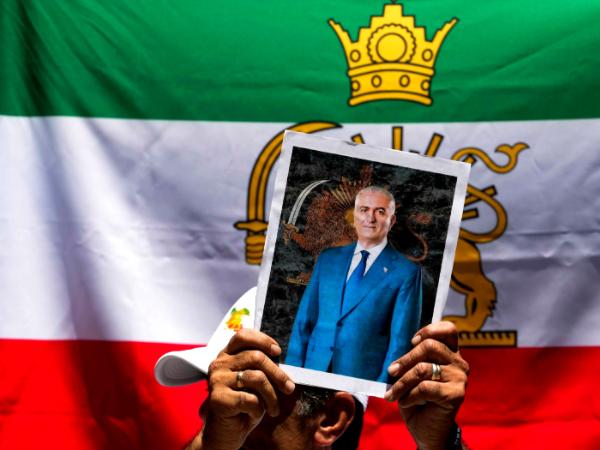 Jeden z protestujących pod ambasadą Iranu w Santiago trzyma portret Rezy Pahlawiego, 13 stycznia 2026 r.