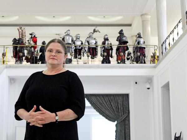 Krystyna Pawłowicz na tle zbroi