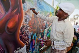 Haitański artysta pracuje nad freskiem na betonowym masowym grobie. To opowieść o tragedii, ale przepełniona wiarą w przyszłość.
