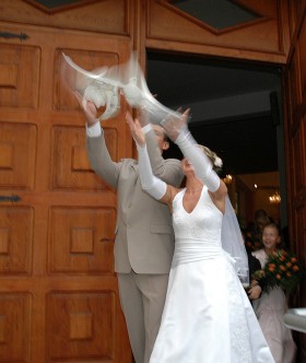 Zmieniają się mody. Na nowożeńców mogą czekać także deszcz: konfetti, ryżu albo monet. Istnieją też lokalne tradycje. Młoda para z Dąbrowy Górniczej wypuszcza białe gołębie na szczęście. Październik 2005 r.