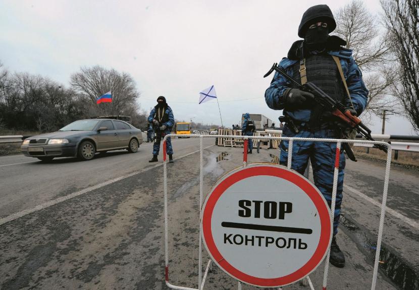 Pod flagą Rosji i banderą rosyjskiej marynarki wojennej odcięto półwysep od Ukrainy, by go chronić przed rzekomym „desantem NATO” (Armiańsk, 28 lutego 2014 r.).