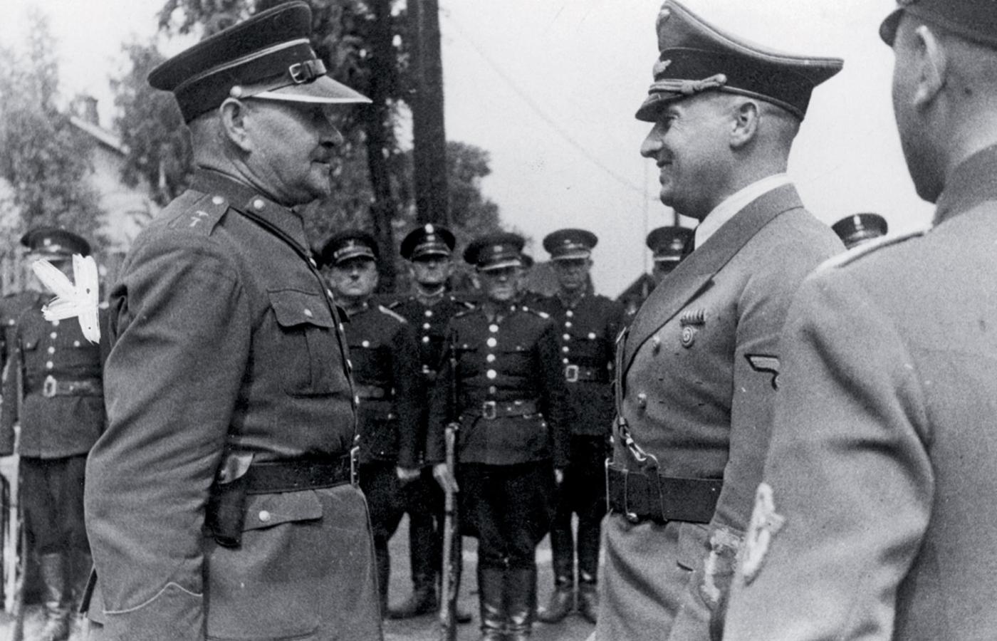 Gubernator Hans Frank (z prawej) przyjmuje meldunek od komendanta oddziału polskiej granatowej policji, 1940 r. W tle stoją polscy policjanci.