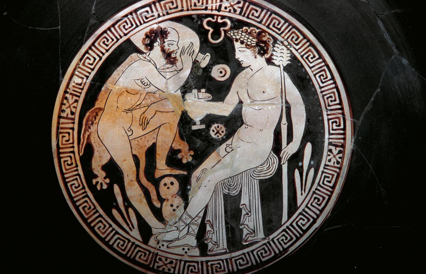 Starożytna grecka ceramika z pijącymi wino mężczyznami.