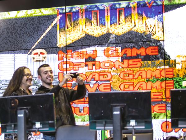 John Romero (po lewej) na tle oryginalnego menu gry „DOOM”, Milan Games Week, 2016 r.