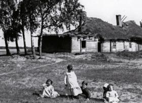 Dzieci chłopskie z Celejowa na Mazowszu, w tle czworaki, czyli mieszkania dla służby folwarcznej, 1903 r.