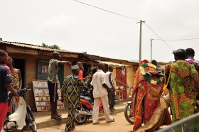 Egungun, duch zmarłego, w różnobarwnym, kunsztownym kostiumie tańczy w środku pochodu pogrzebowego.