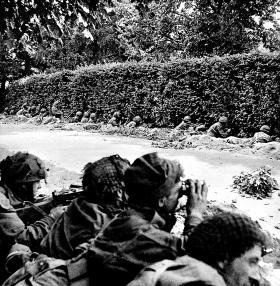 „Czerwone Diabły” (nazwani od bordowego koloru beretów) zatrzymani przez Niemców na przedmieściu Arnhem. Spadochroniarze okopują się, sądząc, że do obrony przechodzą tylko na chwilę.