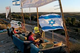 Izraelczycy patrzą na bombardowaną Strefę Gazy.