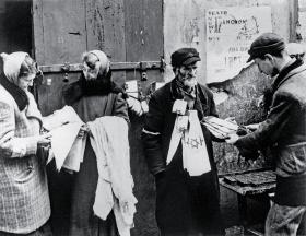 Sprzedawca obowiązkowych opasek. O represjach i zasadach panujących w dzielnicy nie pisano.